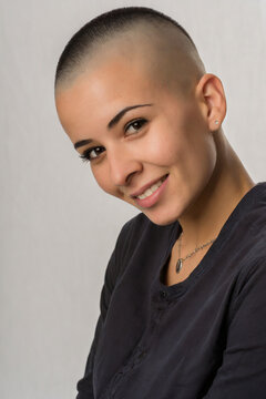 jeune fille souriante aux cheveux ras&eacute;s
