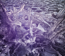 Abstract formation of ice crystals by frozen lake in purple