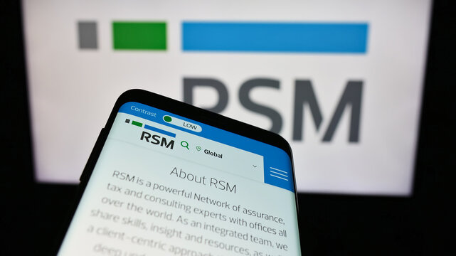 Stuttgart, Germany - 12-20-2023: Mobile phone with website of global accounting company RSM International Ltd. in front of business logo. Focus on top-left of phone display.