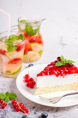 Cheesecake with fresh strawberries, red currants and blueberries. Refreshing strawberry lemon summer cocktail Homemade cheese pie