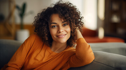 Smiling woman with curly hair in a warmly lit room