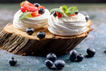 The process of making Pavlova dessert. Pavlova dessert with fresh slices of strawberries,...