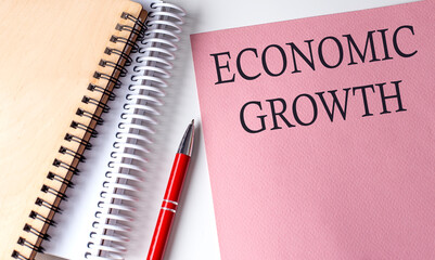 ECONOMIC GROWTH word on the pink paper with office tools on white background