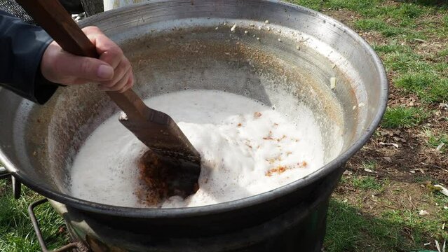 Stirring fat in a large vat on the coals. Pork rind is the culinary term for skin of a pig. It can be rendered, fried in fat, baked, roasted to produce pork cracklings or scratchings. Serbia Srem