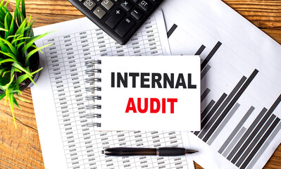 INTERNAL AUDIT text on a notebook with chart and calculator
