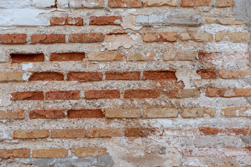 Weathered Red Brick Wall with Peeling Plaster
