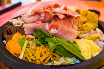 Taiwanese Cuisine Hot Pot with Pork, Bacon Slices Vegetables and Herbs
