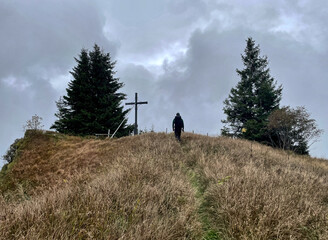 Wanderer auf dem Weg zum Gipfelkreuz des Karkopf bei bewölktem Wetter, Alpen, Bayern, Deutschland,...