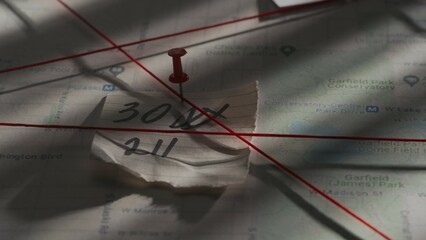 Close up shot of investigation board. Detective board with map of crime scene, pinned note with...