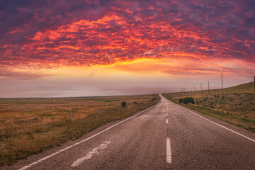 Road into sunset with dramatic sky and clouds. Armenia 