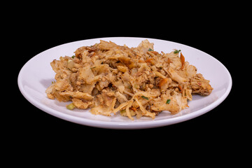 Sri Lankan kottu roti on a white plate against a black background