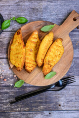 
 Crispy home made  deep fried   chicken strips . Breaded  with cornflakes chicken  breast fillets  with chilly peppers and fresh   basil on wooden rustic background