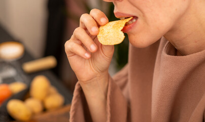 43 year old woman eating chips close up, natural shot
