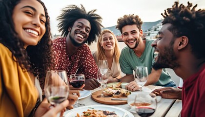 Multiethnic friends having fun at rooftop bbq dinner party , Group of young people diner together sitting at restaurant dining table , Cheerful multiracial teens eating food and drinking wine outside - obrazy, fototapety, plakaty