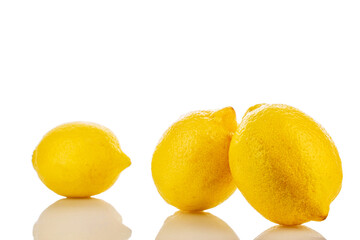 Three yellow juicy lemons, macro, isolated on white background.