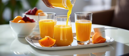 Fresh juices being poured at hotel breakfast table in the morning. - obrazy, fototapety, plakaty