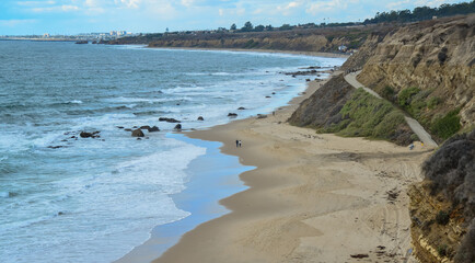 Wide sandy beach where people walk during a storm, Pacific Ocean, Malibu area