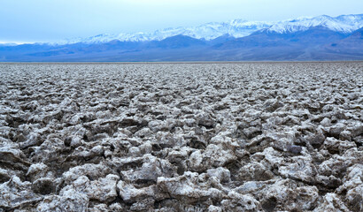 Death Valley National Park, Salt with clay, California. Smooth salt valley with cracked and swollen...