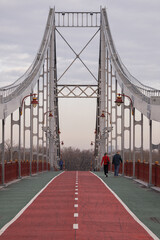 Kyiv, Ukraine - December 29, 2023: Trukhaniv bridge connecting the two banks of Kyiv. This is a pedestrian bridge on which people walk, cyclists ride and athletes run.