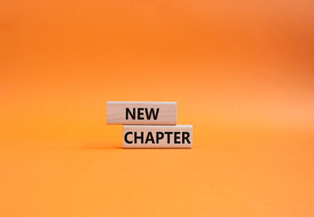 New Chapter symbol. Concept word New Chapter on wooden blocks. Beautiful orange background....