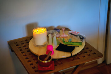 A plate with candle and acupuncture therapy related tools such as jade massager, medicine and stone for cosmetic procedure,