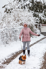 Woman with a dog walks outside in winter