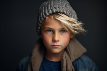 Portrait of a cute little boy in a knitted hat and scarf. Studio shot.