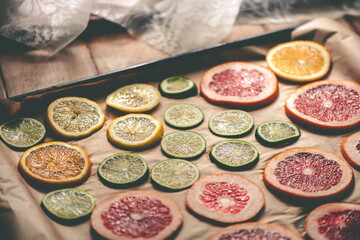 Sliced orange, tangerine and grapefruit slices on baking sheet, preparing citrus wedges for...