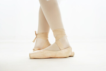 Ballerina legs third position in pointe, ballet dancer closeup background