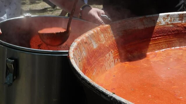 Tomato soup with pasta is a dish of Polish cuisine. Hot Zupa pomidorowa in a large cauldron at the field kitchen at a food fair. A popular soup made from grated tomatoes in their own juice.