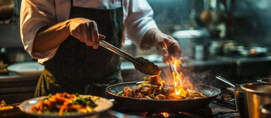 Gordijnen Busy chef cooking stir-fry in kitchen. © TheWaterMeloonProjec