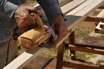 pedreiro serrando madeiras com ferramenta de corte 
