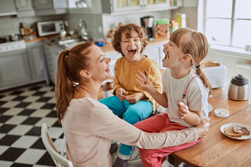 Mother and children having fun with chocolate in the kitchen