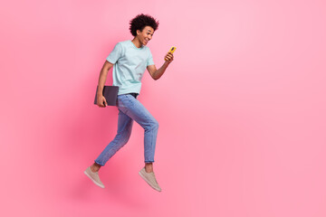 Fototapeta na wymiar Full size photo of nice young guy running fast hold device netbook wear trendy blue outfit isolated on pink color background