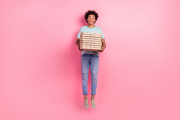 Full size photo of nice young guy jumping deliver pizza boxes wear trendy blue outfit isolated on...