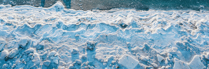 Top view of the icy shore. Aerial photograph of the freezing sea. Ice floes on the coast. Nature of...