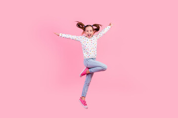 Full size photo of optimistic schoolgirl dressed dotted pullover denim pants fly hold arms like...