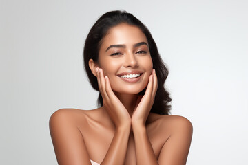 Beautiful happy young Indian woman touching her face caring for facial skin. Skincare concept