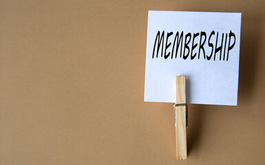 MEMBERSHIP - word on white sheets of paper with clothespins on a coffee background