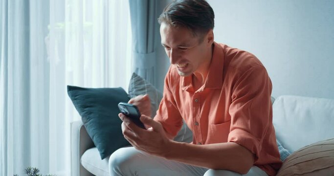 Man immersed in online game on his smartphone joyous at each victory The thrill of online game blend of skill and excitement. Online game win brings outbursts of happiness showcasing digital era joys.