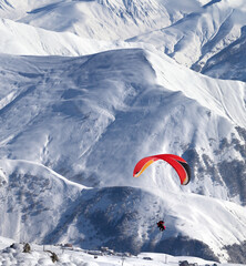 Paragliding at snowy mountains over ski resort