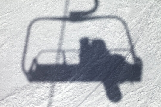 Shadows from chair lift with snowboarder