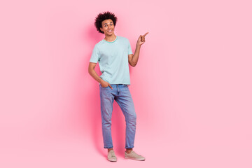 Full size photo of nice young guy point empty space promo advert wear trendy blue outfit isolated on pink color background