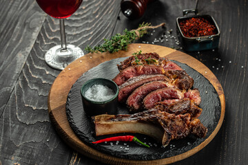 sliced rib eye Tomahawk beef veal steak on a dark background. top view. copy space for text