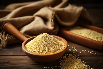 Organic millet grains scattered on a rustic table with a wooden scoop and burlap sack in the frame