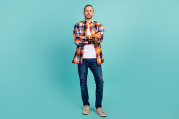 Full size photo of serious brutal man dressed checkered shirt denim pants standing hold arms crossed isolated on teal color background