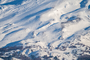 Bronte town under the snowy and majestic volcano Etna and a cloudy blue sky