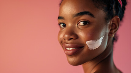 Close-up beauty shot featuring the face of a young brunette woman with a small drop of cream on her skin. Promotional image for a cream emphasizing good skin health. Pink background. - obrazy, fototapety, plakaty
