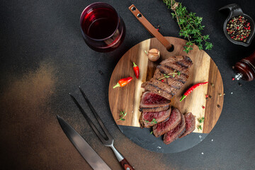 Grilled sliced skirt beef meat steak on a dark background. top view. copy space for text