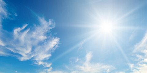 Cumulus clouds and bright sun in the sky. Wide photo. - Powered by Adobe